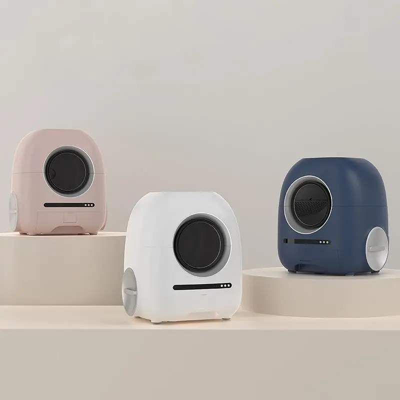 Rounded smart cat litter boxes in blush pink, white, and navy blue on display.