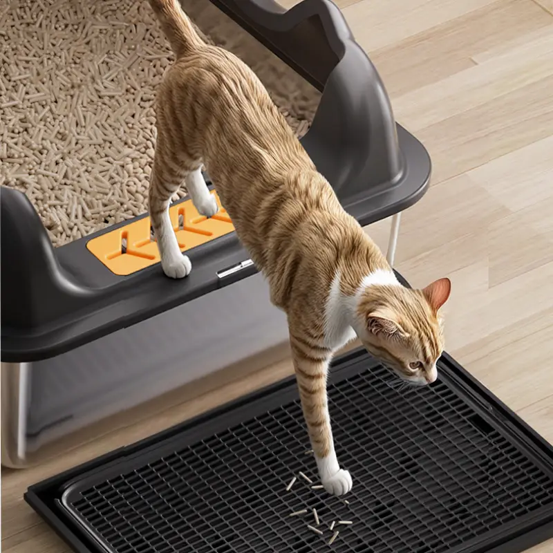 A ginger cat walks on a mesh pad of a stainless steel cat litter box, highlighting the hygienic and easy-to-clean pet supply design.